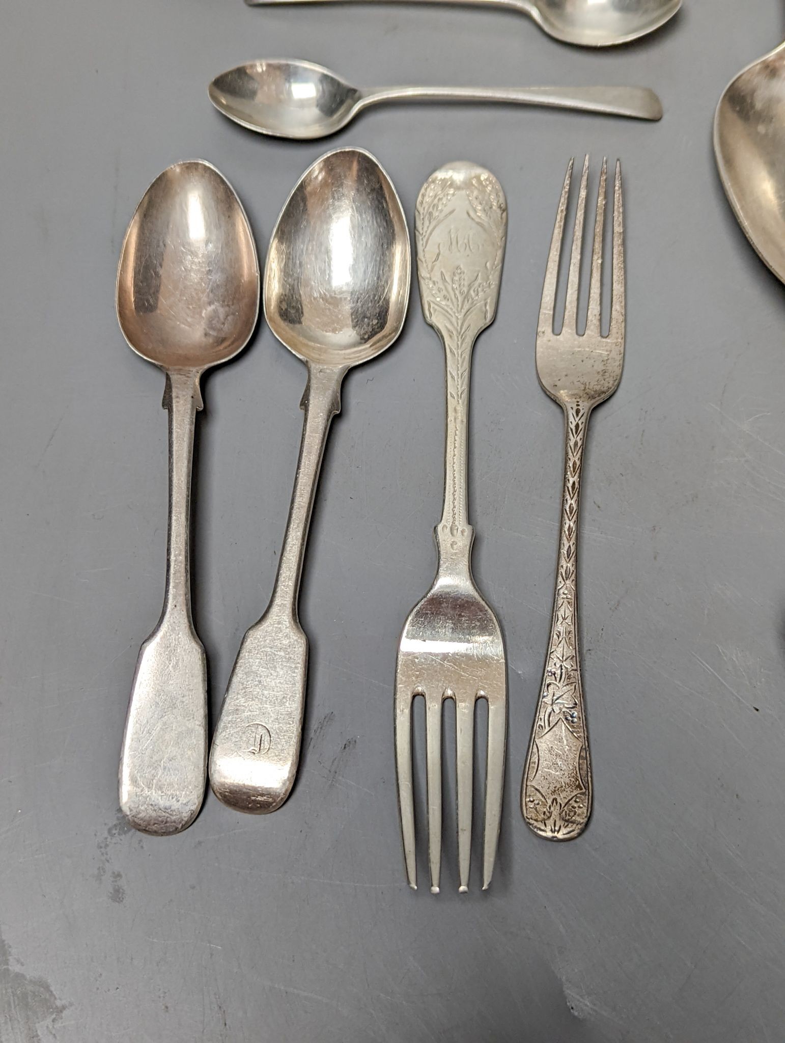 A small quantity of assorted mainly 19th century silver flatware including a pair of George III Old English pattern table spoons, Smith & Hayter, London, 1794 and a silver butter knife, 15oz